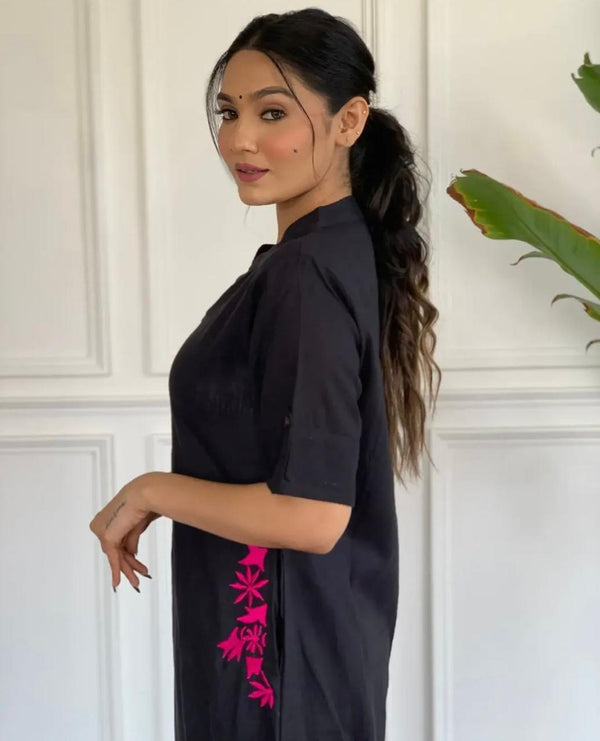 Woman wearing black A-line cotton suit for women with pink floral embroidery on side