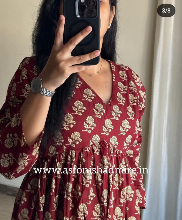Woman wearing casual printed middy gown in maroon with floral patterns by THREAD JAIPUR
