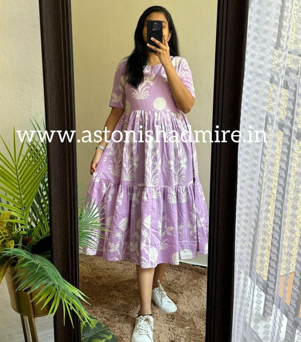 Woman wearing a purple print middy gown with floral patterns and tiered design by THREAD JAIPUR