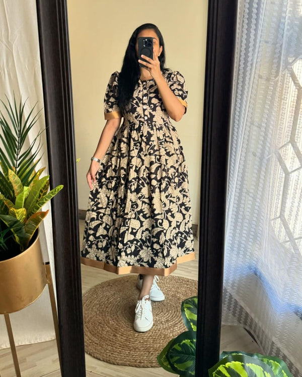 Woman wearing Azrak print summer dress by Jaipuri Pehnawa standing in front of mirror with white sneakers