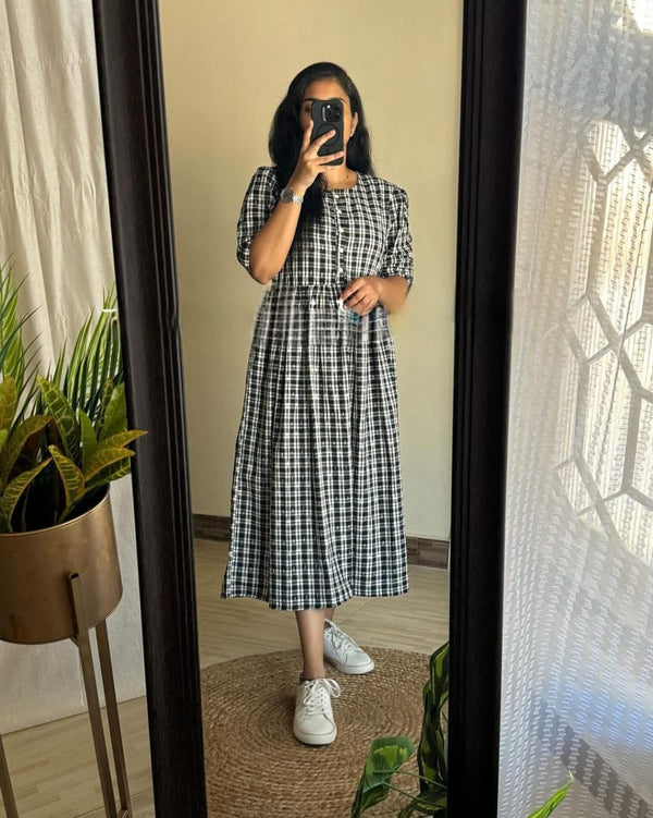 Black and white cotton middy gown by  Cotton Suit worn by woman with white sneakers posing in mirror