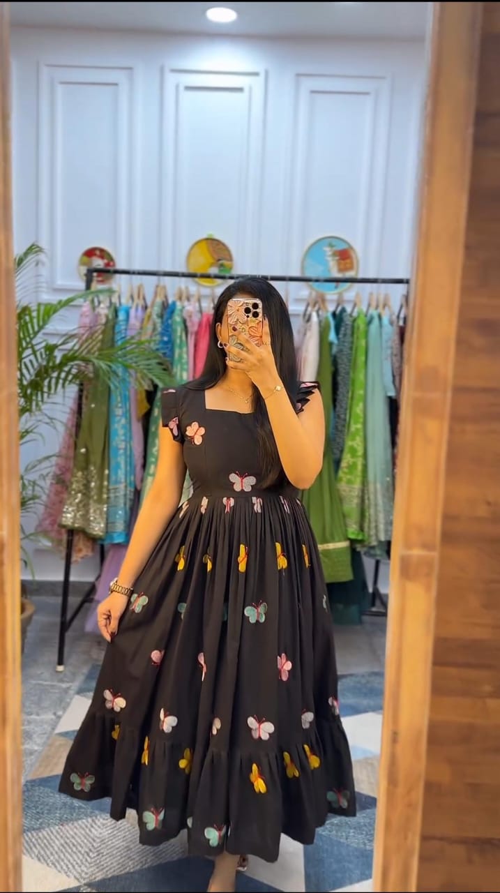  black butterfly embroidery midi dress worn by woman in boutique fitting room
