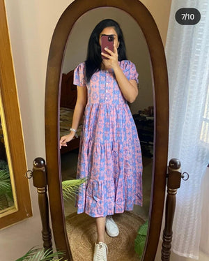 Sugamdha blue cotton midi dress with floral patterns worn by woman with white sneakers