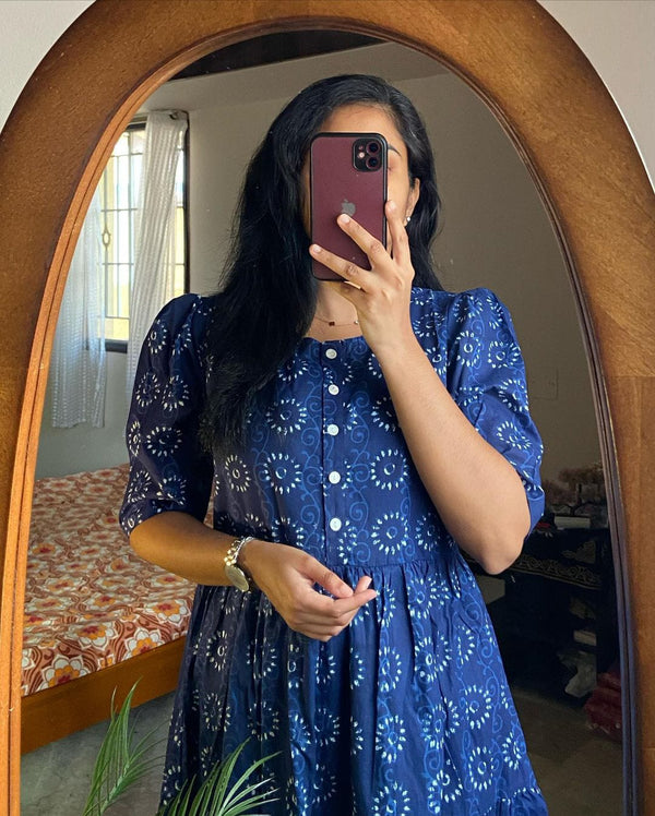 Woman wearing a blue cotton midi dress for women with white circular patterns taking a mirror selfie