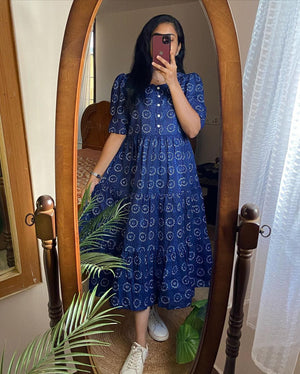 Woman wearing a blue cotton midi dress for women with puff sleeves standing in front of a mirror