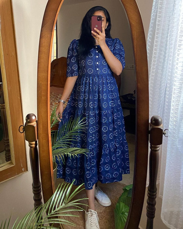 Woman wearing a blue cotton midi dress for women with white floral print standing in front of a full-length mirror