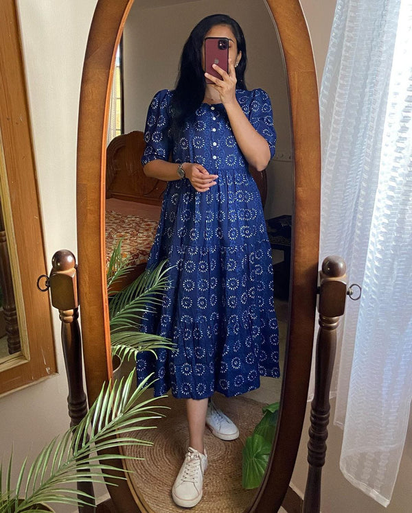 Woman wearing a blue cotton midi dress for women with white sneakers standing in front of an oval mirror