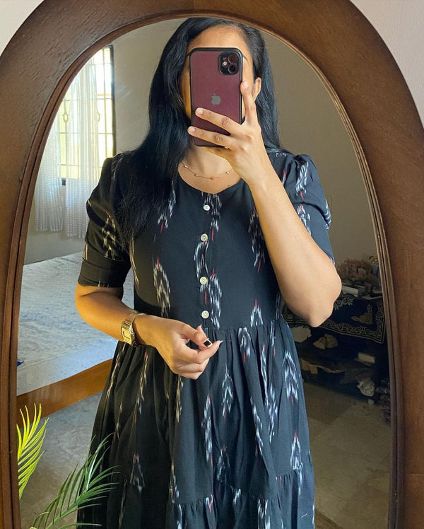 Woman wearing casual summer cotton gown for women in black with button details and pattern taking mirror selfie