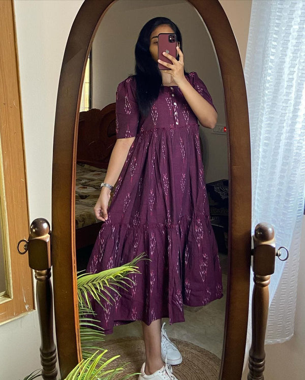 Woman wearing a purple casual summer cotton gown for women taking a mirror selfie indoors