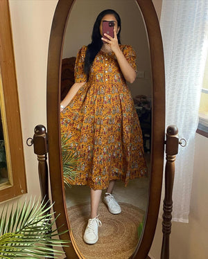 Woman wearing yellow printed comfortable summer dresses for everyday use by Cotton Suit in front of a mirror
