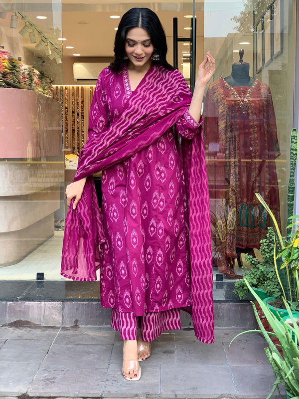 Woman wearing pink cotton embroidered kurta pant dupatta set standing outside a store