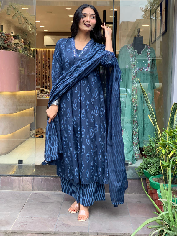 Woman wearing blue cotton embroidered kurta pant dupatta set standing outside a shop