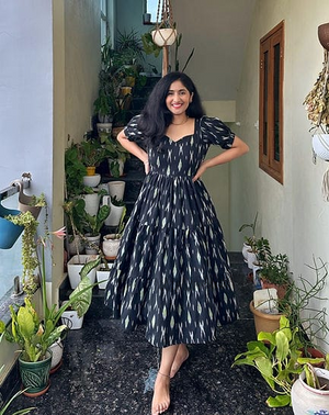 Woman wearing  Cotton Suit black cotton middi gown for women with puff sleeves and patterned design