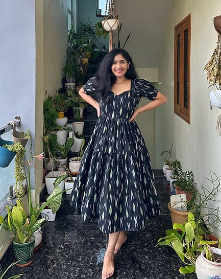 Woman wearing  Cotton Suit black cotton middi gown for women with puff sleeves and patterned design