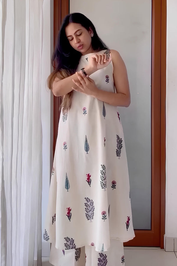 Woman wearing white ethnic wear handblock design dress with sleeveless style and floral patterns