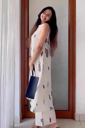 Woman wearing Cotton Suit ethnic wear handblock design white kurta and pants holding navy blue bag