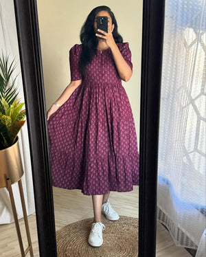 Woman wearing a purple floral printed cotton maxi dress with short puff sleeves and white sneakers
