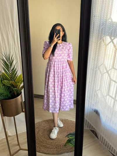 Woman wearing a pink and white full flair middy gown for women with short sleeves and sneakers
