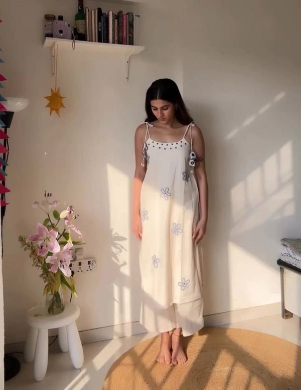 Woman wearing a hand work ethnic cotton suit in white with floral embroidery by Cotton Suit