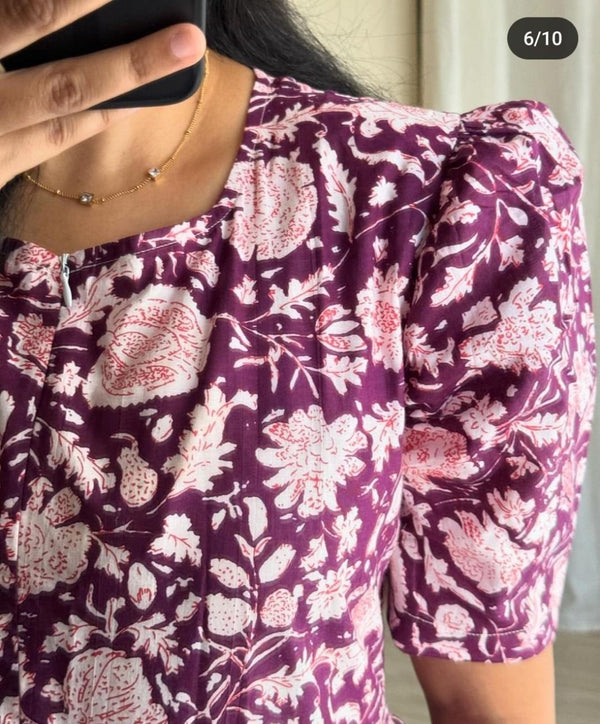 Close-up of  Cotton Suit Ikkat print gown in purple with pink floral patterns and puffed sleeves