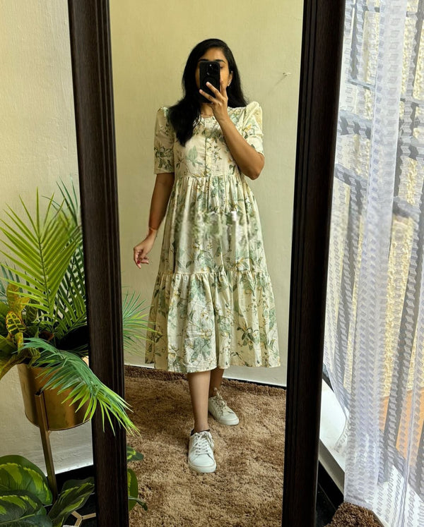 Woman wearing a lightweight casual maternity maxi dress with floral print standing in front of a mirror