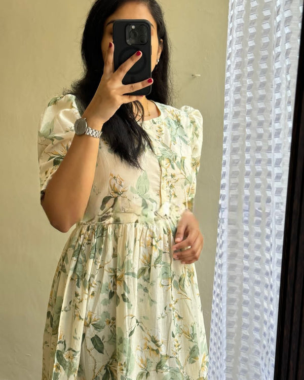 Woman wearing lightweight casual maternity maxi dress with floral print taking a mirror selfie