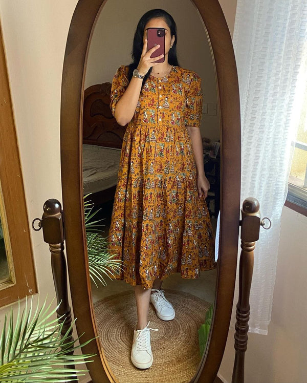 Cotton Suit mustard cotton midi dress with short sleeves and a floral pattern worn with white sneakers