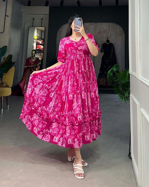 Jaipuri pehnawa pink flowy maternity gown with floral design worn by woman in white sandals