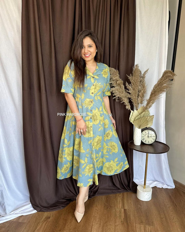Cottonsuit casual a-line cotton dress in blue with yellow floral print worn by woman indoors