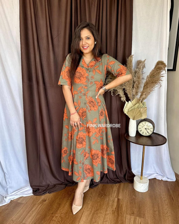 Cottonsuit casual a-line cotton dress in olive green with orange floral print worn by woman indoors
