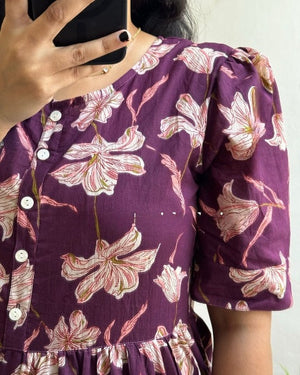 Purple floral maxi dress with sleeves featuring white and pink flower print and button details