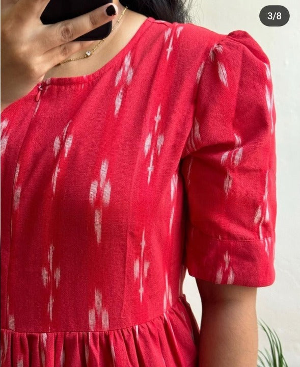 Close-up of red cotton printed midi gown by Cotton Suit with puff sleeves and round neckline