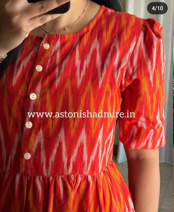 Close-up of rust orange ikkat middy gown featuring a buttoned front and puffed sleeves by THREAD JAIPUR