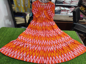 THREAD JAIPUR rust orange ikkat middy gown with vibrant geometric pattern laid flat on green surface