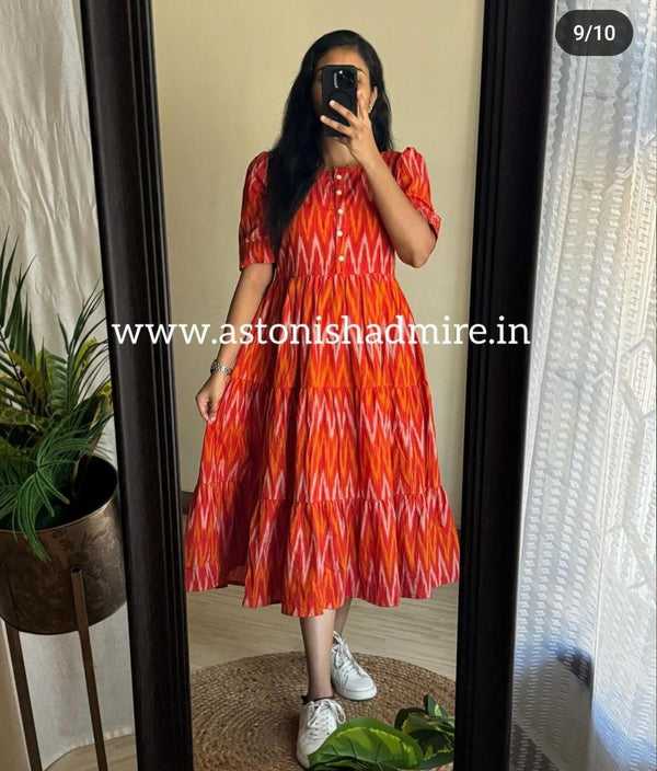 Woman wearing rust orange ikkat middy gown with buttoned front and puff sleeves by THREAD JAIPUR