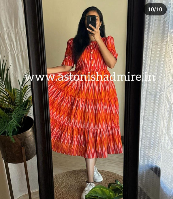 Woman wearing rust orange ikkat middy gown with vibrant geometric patterns and short sleeves from THREAD JAIPUR