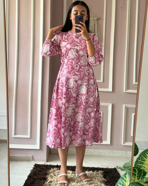 Woman wearing pink floral summer daily wear dress for women from Cotton Suit in a modern room