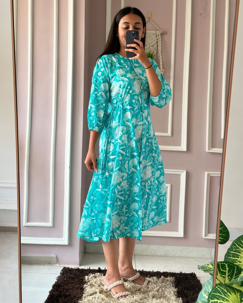 Woman wearing a turquoise floral summer daily wear dress for women with three-quarter sleeves