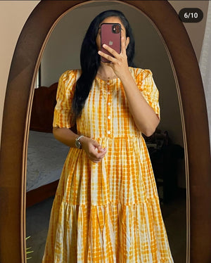 Woman wearing a yellow and white summer ikkat midi gown for women with short sleeves and buttoned front