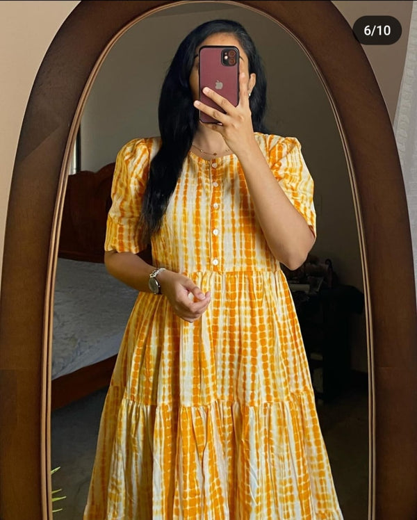 Woman wearing a yellow and white summer ikkat midi gown for women with short sleeves and buttoned front