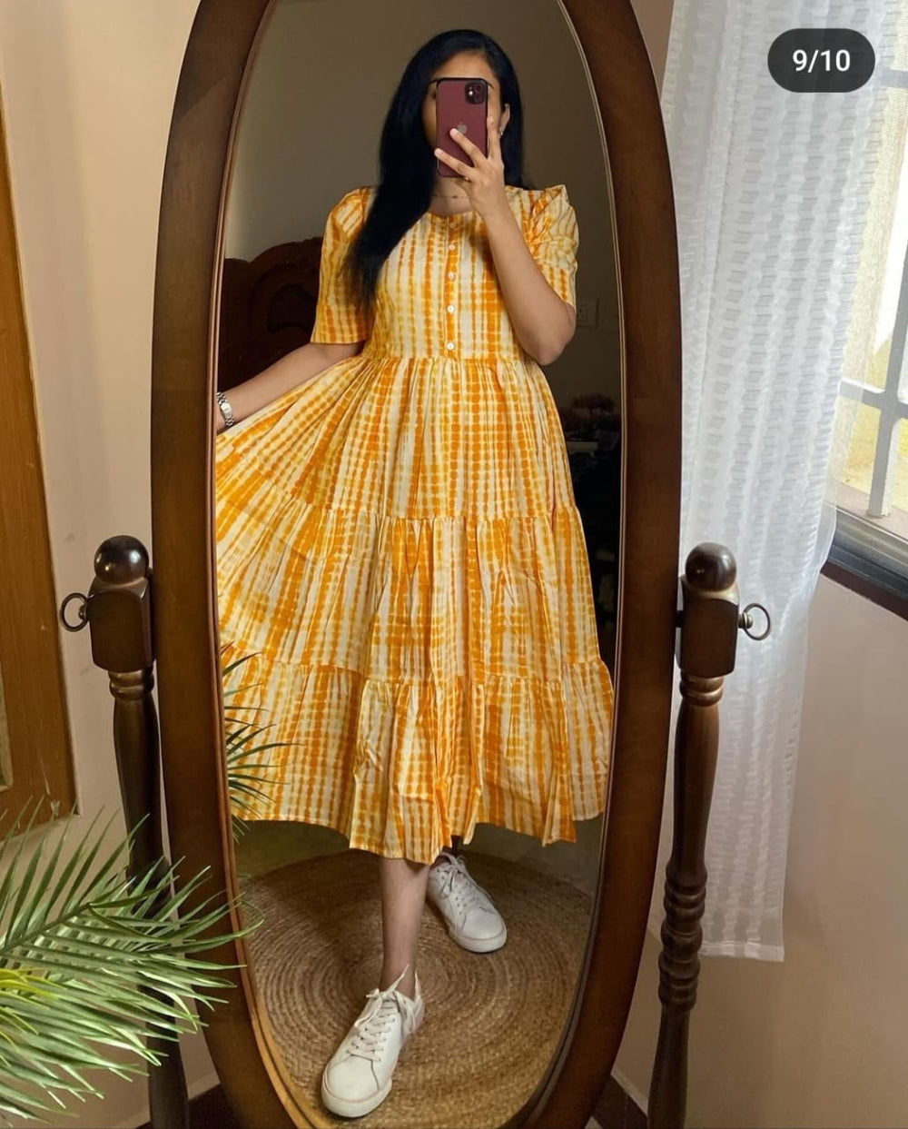 Woman wearing yellow checkered summer ikkat midi gown for women with short sleeves and white sneakers