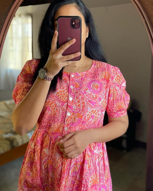 Woman wearing pink lehriya print casual dress for women with floral patterns and buttons
