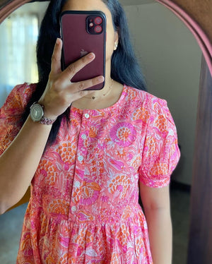 Woman wearing lehriya print casual dress for women in pink and orange floral design from Cotton Suit
