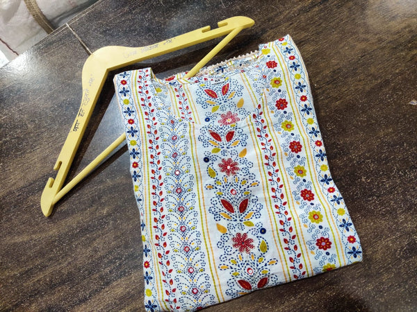 Cotton Suit multicolor printed cotton dress with floral and stripe patterns folded on wooden surface