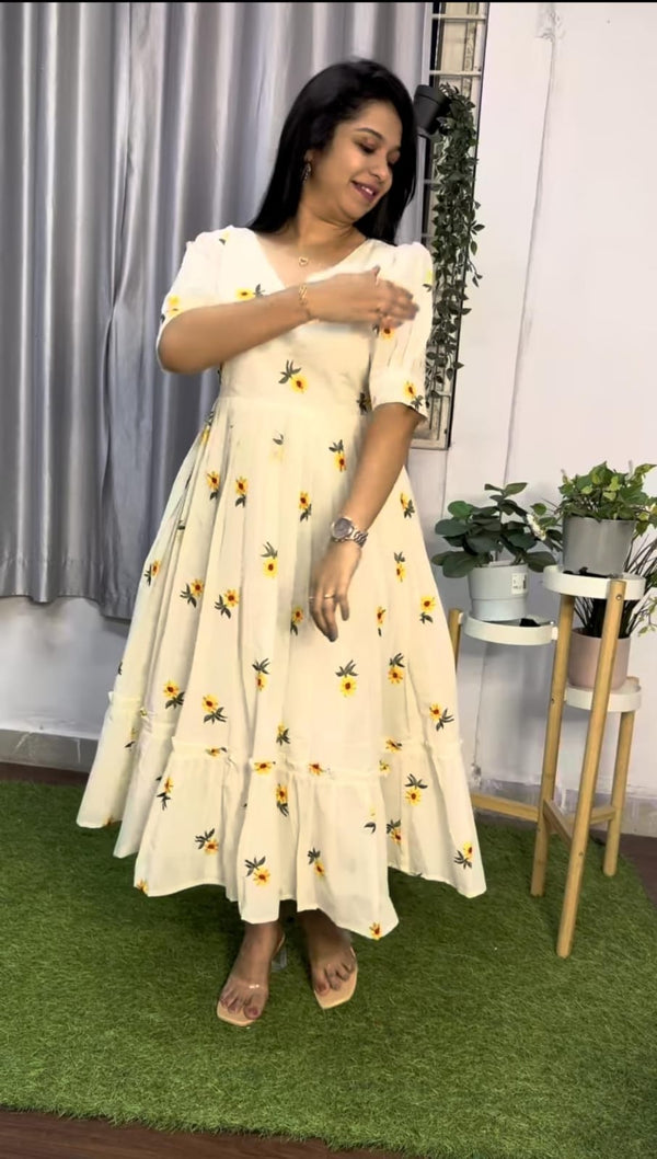  Cotton Suit white cotton embroidered midi dress with floral patterns and ruffled hem worn by a woman indoors