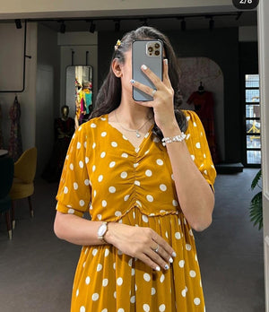 Woman wearing mustard yellow women's casual polka dot gown with ruched front and short sleeves