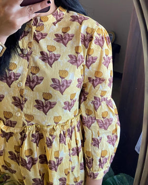 Close-up of Cotton Suit women's flower print midi dress in yellow with maroon floral patterns and puff sleeves