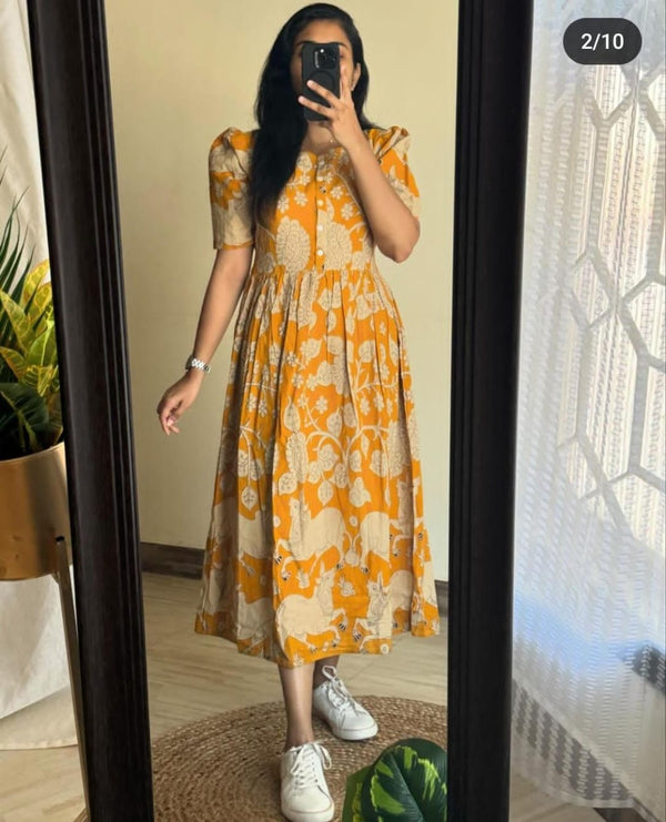 Women wearing yellow and beige floral women's midi cotton gown standing in front of a mirror
