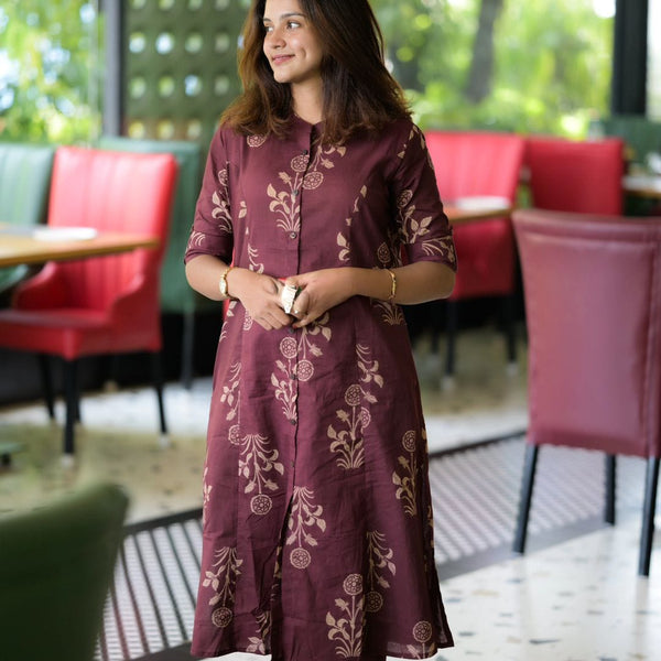 Woman wearing women's premium cotton co-ord set in maroon with floral prints standing indoors
