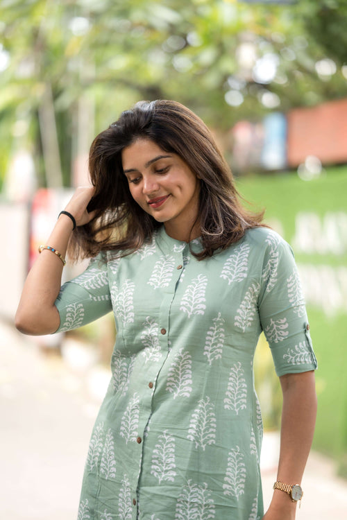 Woman wearing a green women's summer cotton co-ord suit with white leaf prints and button details